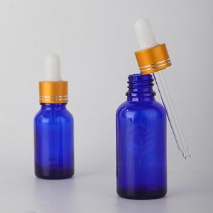 empty glass essential oil blue bottle